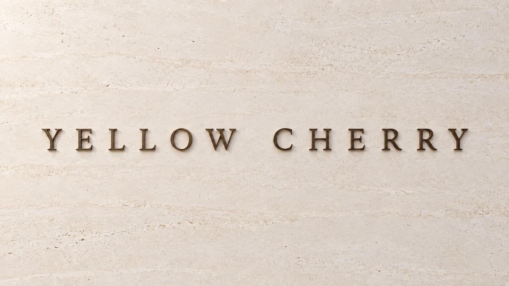 Yellow Cherry lettering on a stone wall