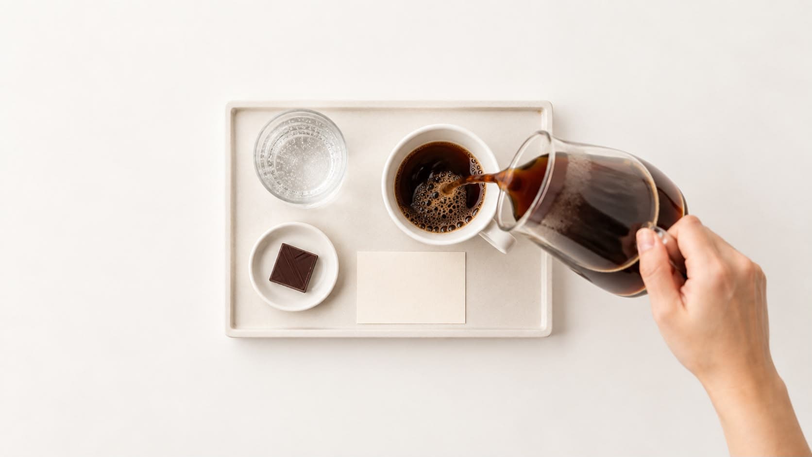 Individual tray with coffee, sparkling water, chocolate, and a coffee card